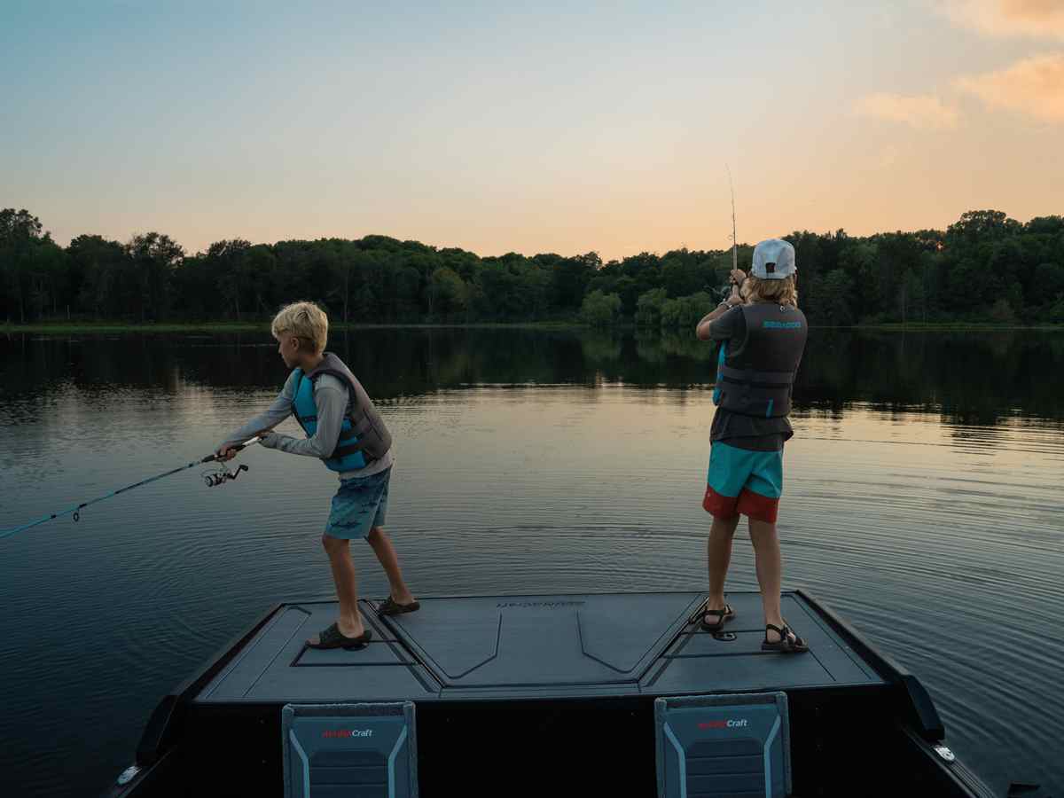 Two kids enjoying the max deck on a Alumacraft Competitor boat