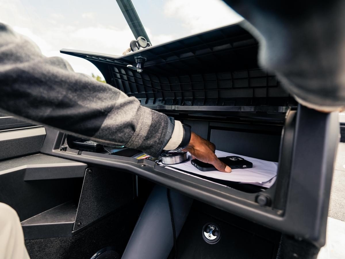 A fisherman using the lockabke storage space of Alumacraft Trophy & Competitor boats