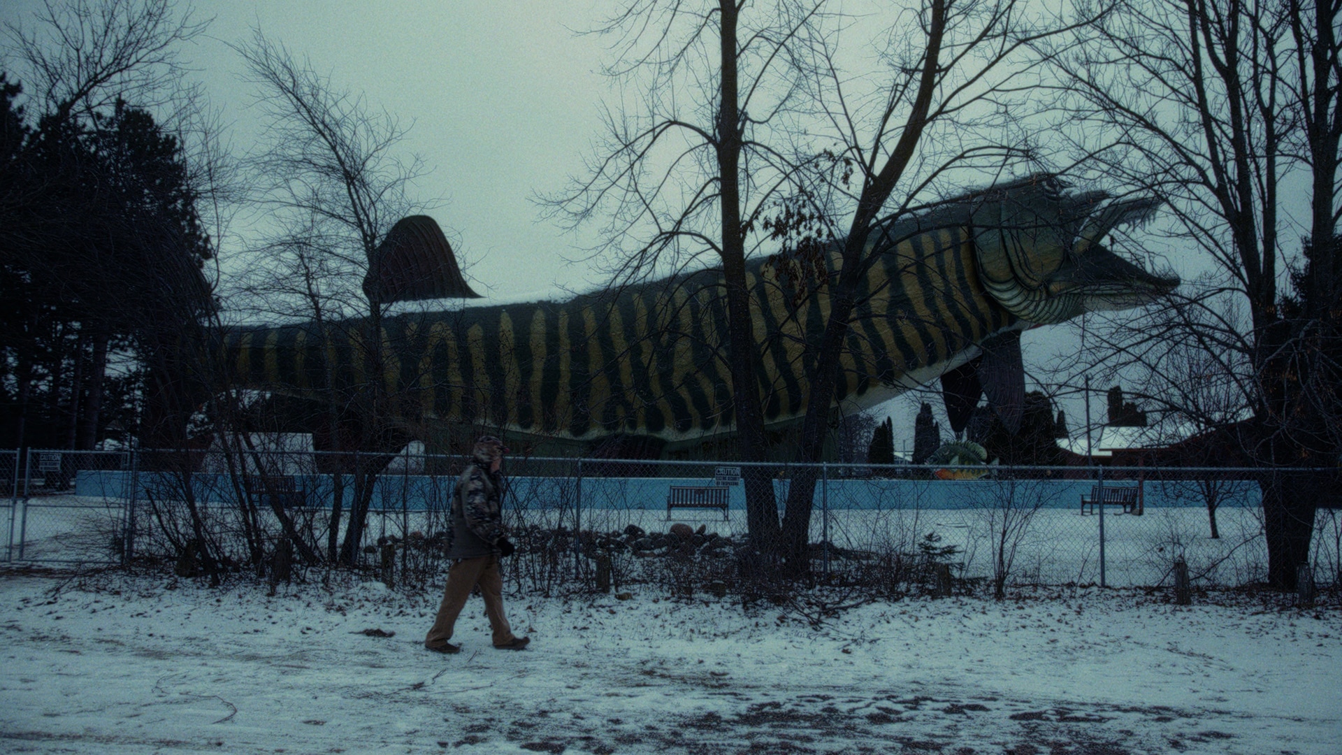 Ramsell aka “MuskieMan” walking in front of a huge fish statue