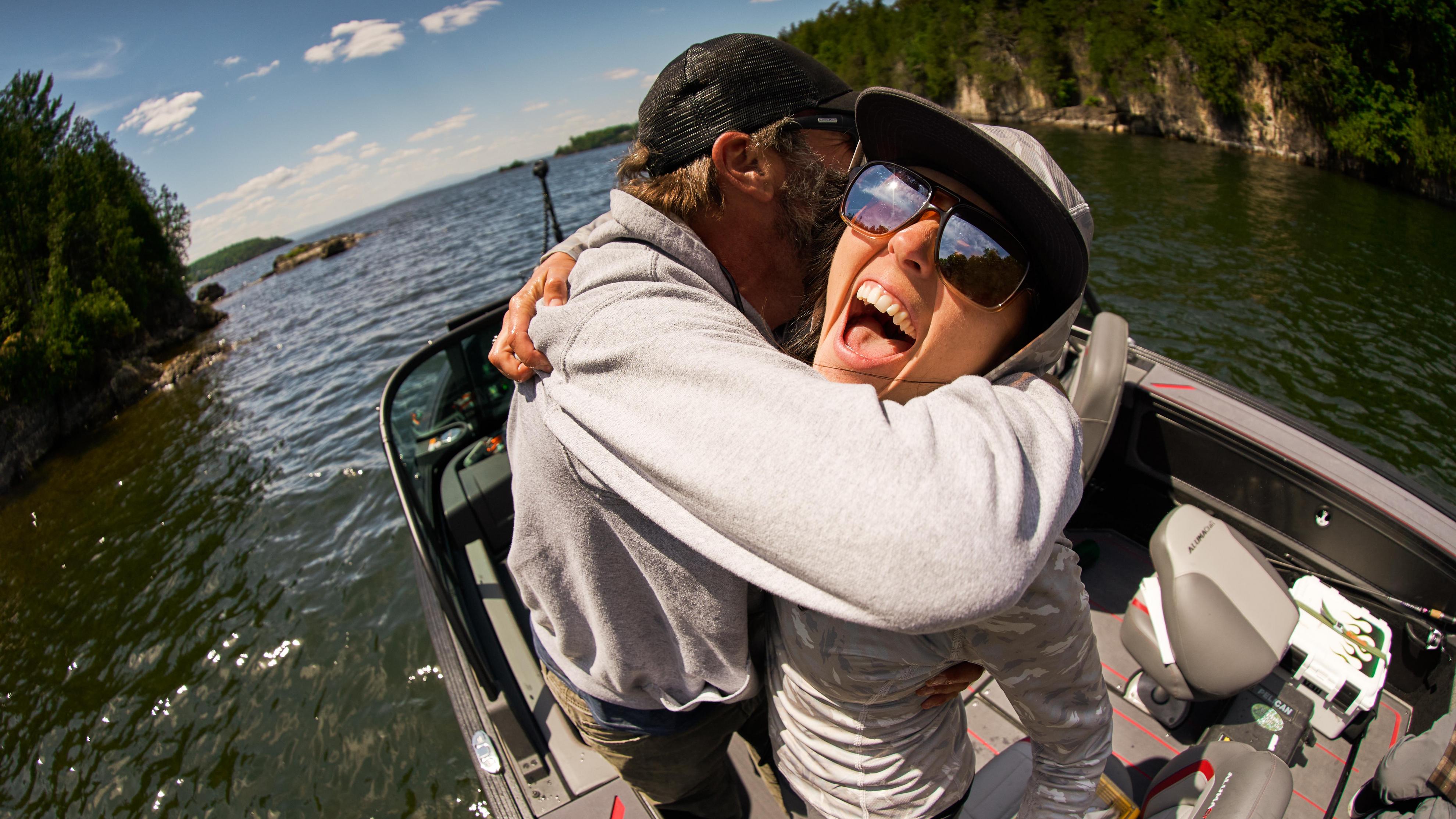 Couple souriant sur leur bateau de pêche Alumacraft