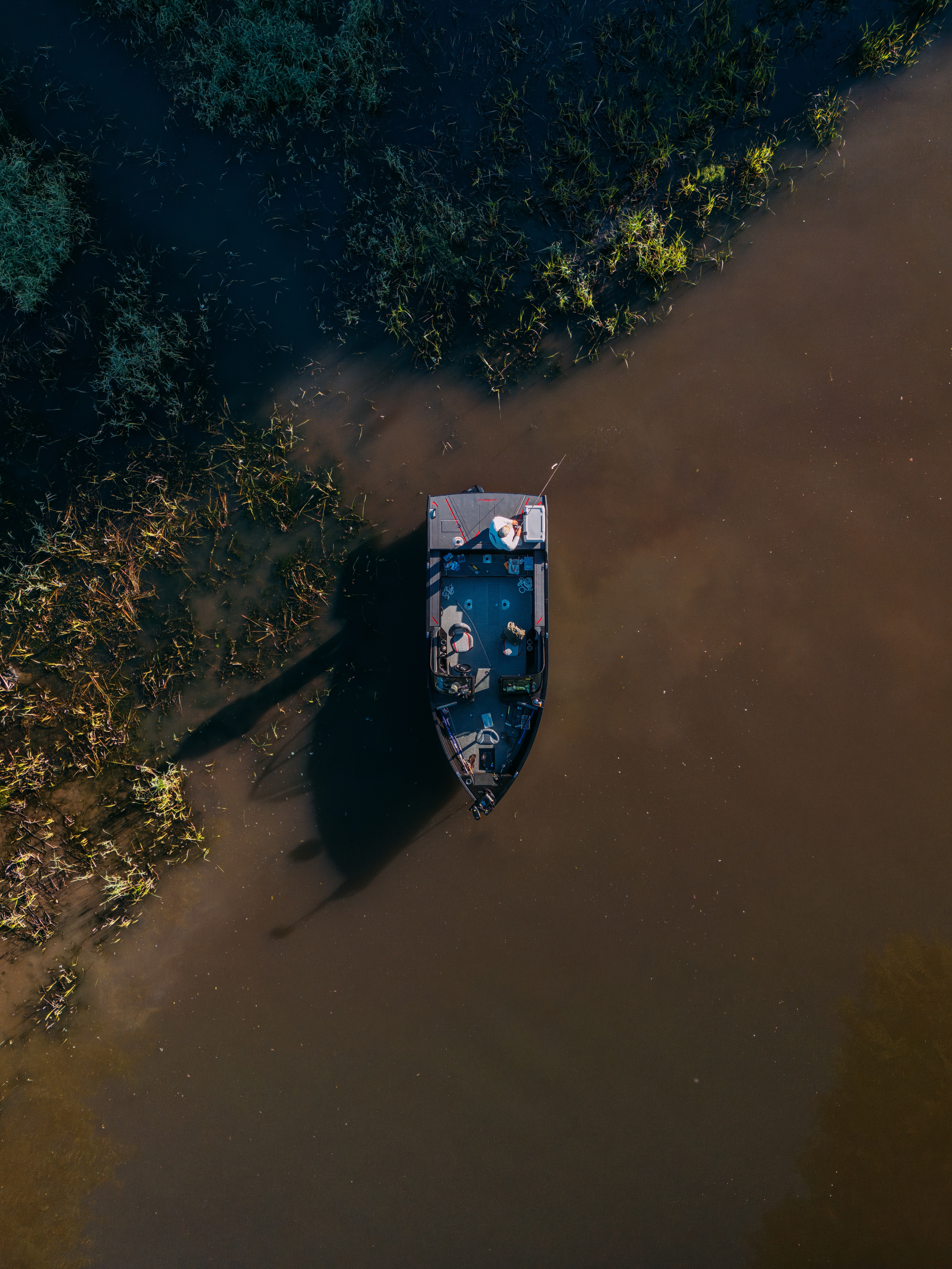 An Alumacraft Trophy 185 2025 boat sailing on a lake at the end of the day. 