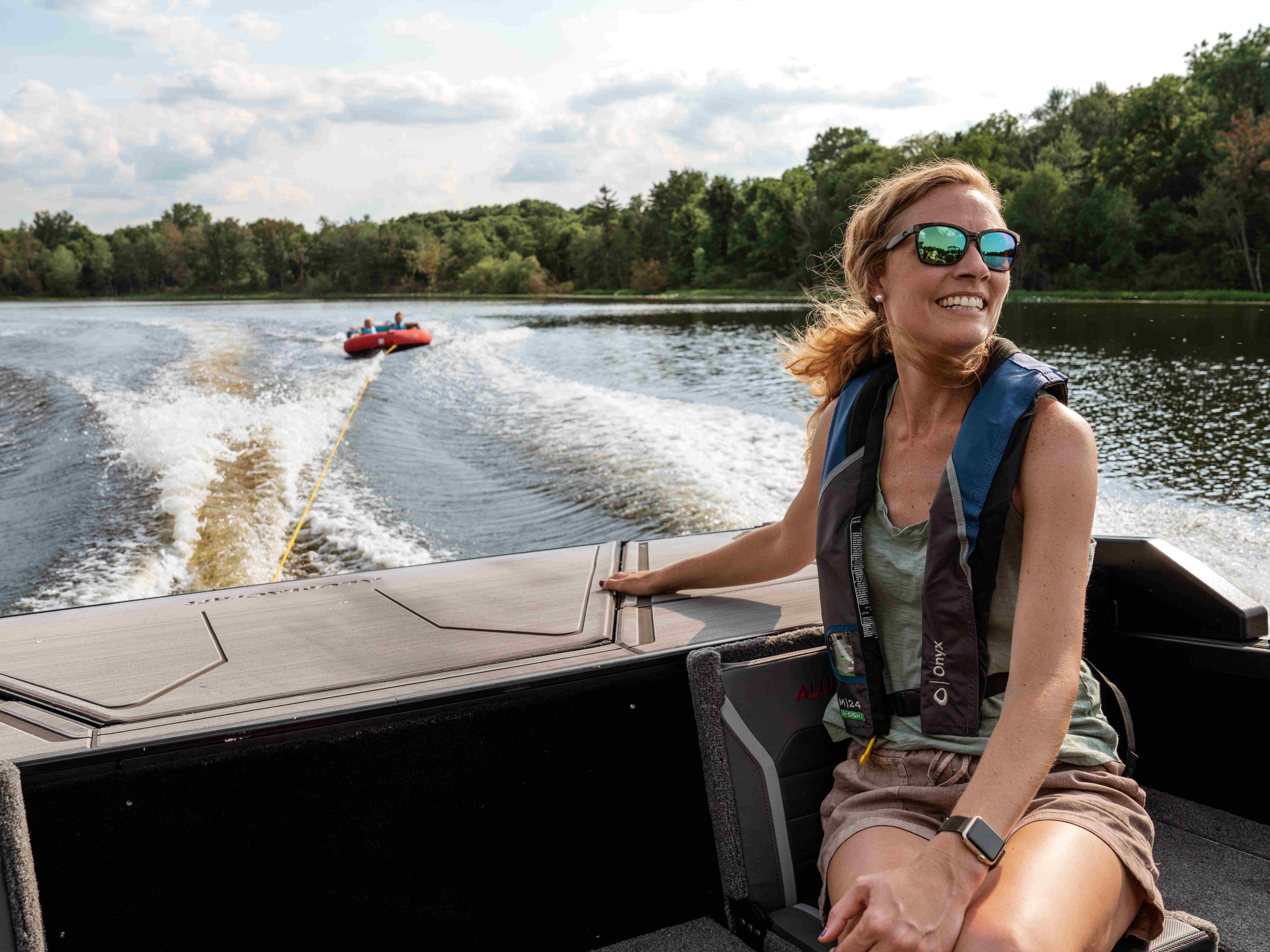 Un modèle Alumacraft Competitor 2025 noir et argent tirant une boué de wakeboard 