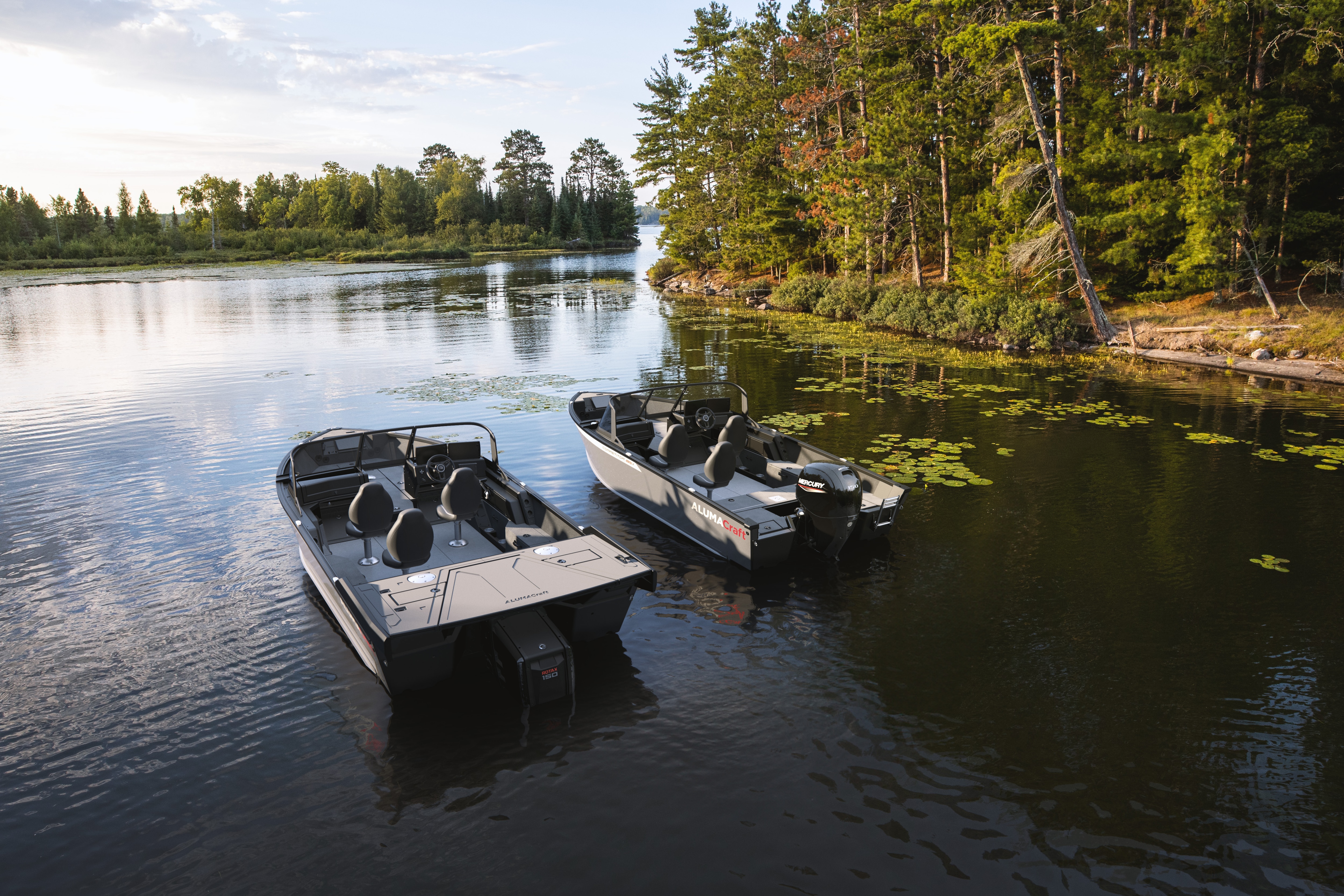 Two Alumacraft Competitor 2025 anchored side by side on a peaceful lake.