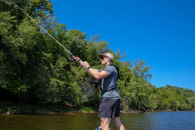Male Angler Casts Fishing Rod into Lake
