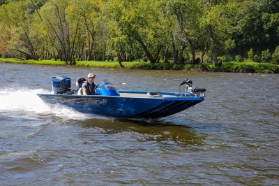 Male Angler Drives Blue Pro 185 Bass Boat on River