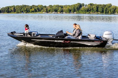 Man, Woman, and Dog Driving A Black Alumacraft 175 Prowler Bass Boat