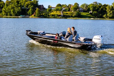 Man, Woman, and Dog Driving A Black Alumacraft 175 Prowler Bass Boat