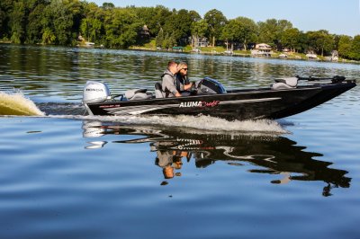 Man and Woman Anglers Driving A Black Alumacraft 175 Prowler Bass Boat