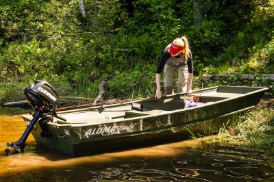 Female Angler Launching 1036 Jon Boat From Lake Shore